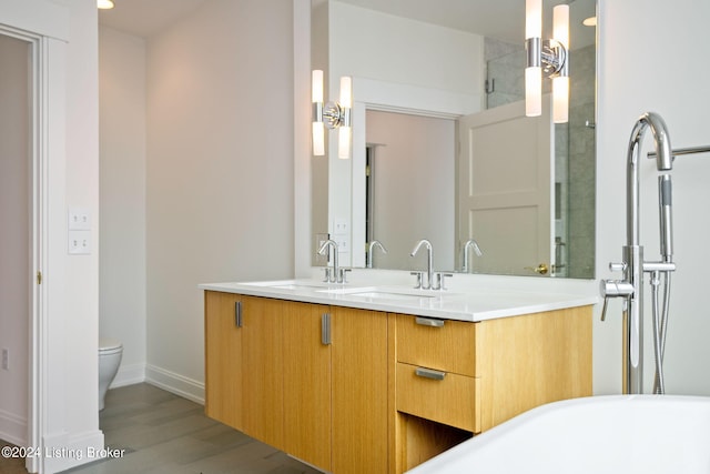 bathroom featuring vanity, toilet, and hardwood / wood-style floors