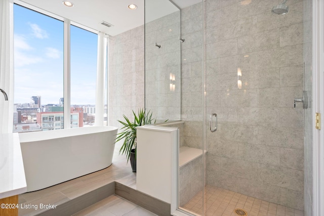 bathroom with a wealth of natural light, tile floors, and independent shower and bath