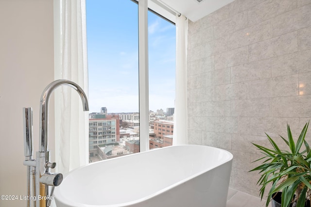 bathroom with tile walls, tile floors, and a washtub