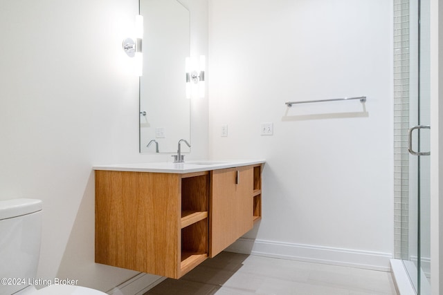 bathroom featuring toilet, a shower with door, tile floors, and vanity