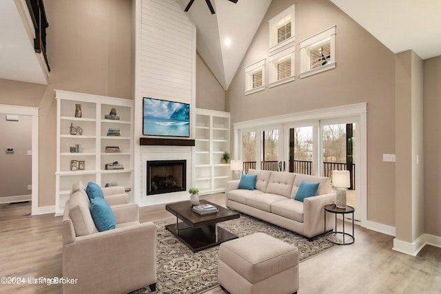 living room featuring high vaulted ceiling and light hardwood / wood-style floors