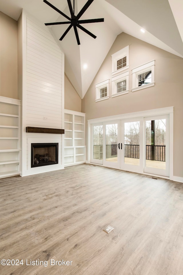 unfurnished living room with a fireplace, light hardwood / wood-style flooring, and high vaulted ceiling