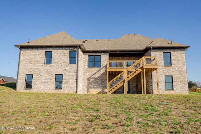 rear view of property with a wooden deck and a yard