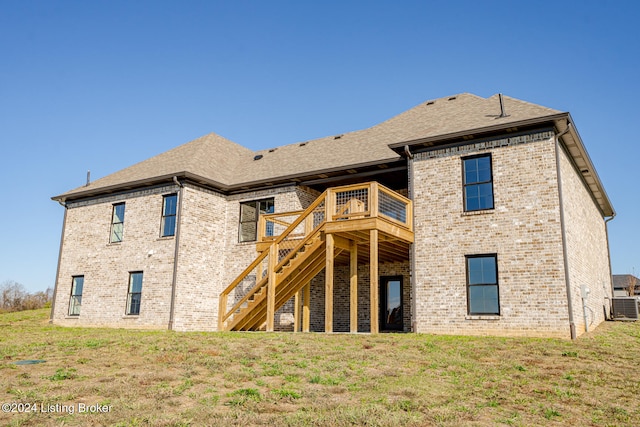 rear view of property with a lawn, a wooden deck, and cooling unit