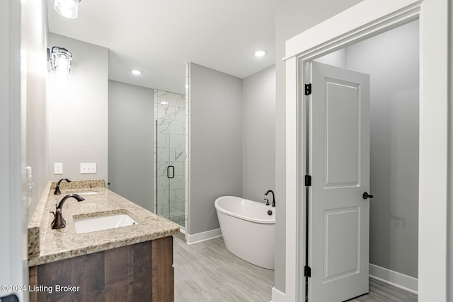 bathroom featuring vanity, hardwood / wood-style flooring, and separate shower and tub