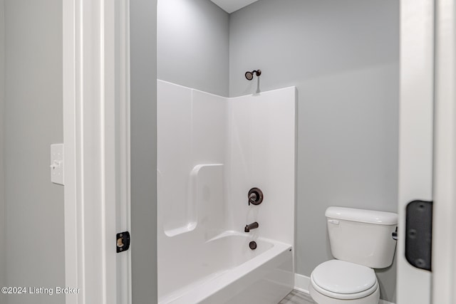 bathroom with bathtub / shower combination and toilet