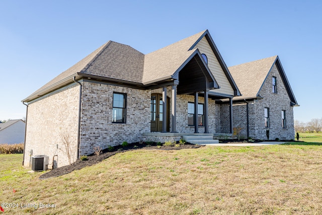 view of front of property with a porch, central AC, and a front lawn