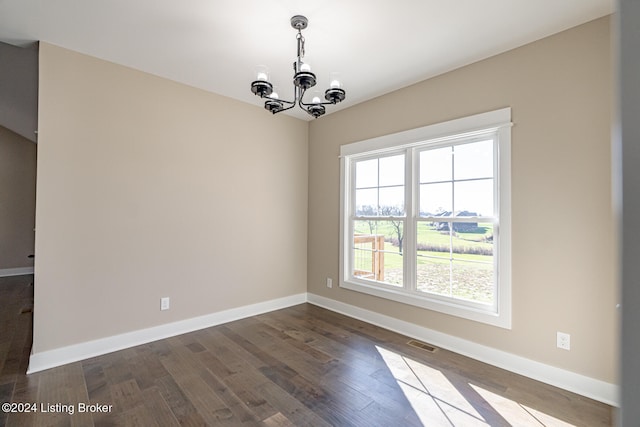 unfurnished room with dark wood-type flooring and an inviting chandelier