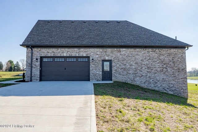 view of side of property with a yard and a garage