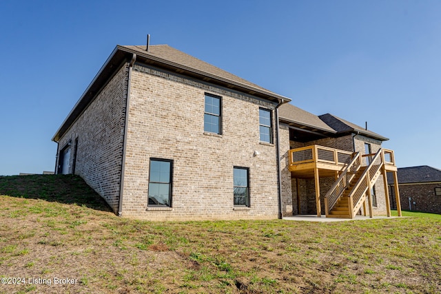 back of house featuring a yard and a wooden deck