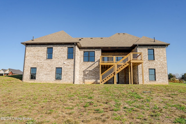 rear view of house with a lawn and a deck