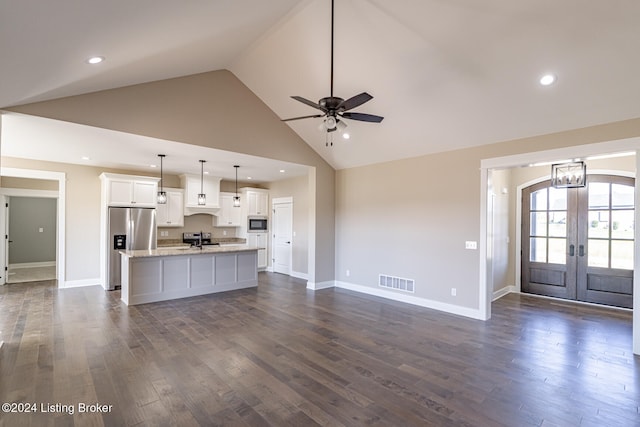 kitchen featuring white cabinetry, dark hardwood / wood-style floors, decorative light fixtures, a kitchen island with sink, and appliances with stainless steel finishes