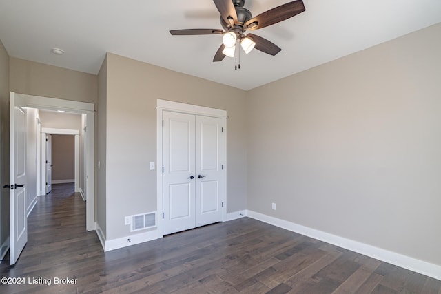 unfurnished bedroom with ceiling fan, a closet, and dark hardwood / wood-style floors