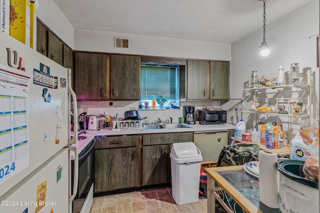 kitchen featuring white fridge, hanging light fixtures, dark brown cabinets, and stove