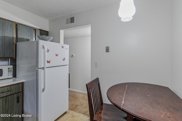 kitchen with white appliances and light colored carpet