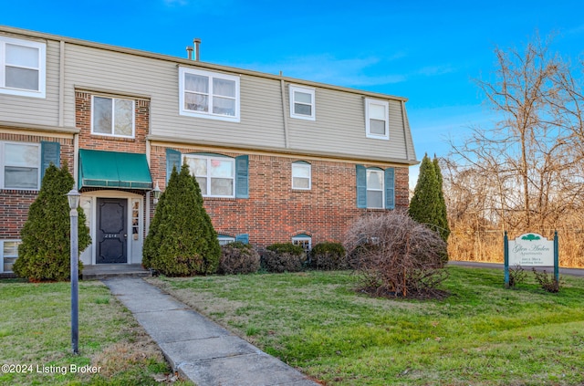 townhome / multi-family property with a front yard