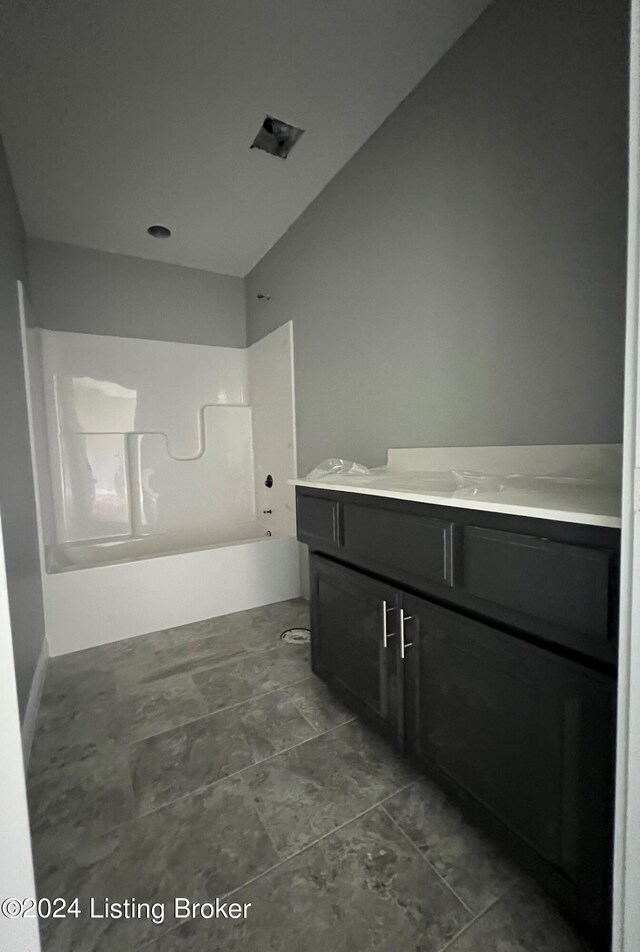 bathroom with tile patterned flooring, shower / tub combination, and vanity