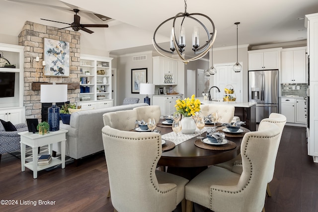 dining area with dark hardwood / wood-style flooring, a fireplace, ceiling fan with notable chandelier, and sink