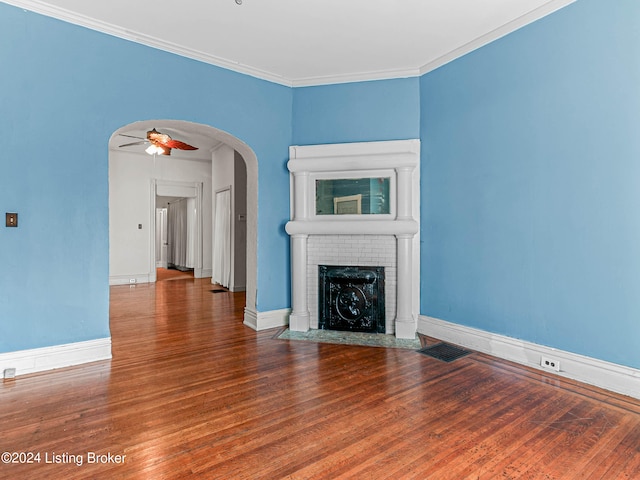 unfurnished living room with ornamental molding, a fireplace, ceiling fan, and dark wood-type flooring