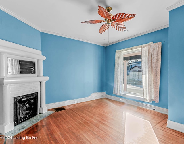 unfurnished living room with ceiling fan, ornamental molding, a fireplace, and light hardwood / wood-style floors