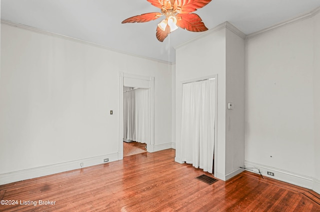 spare room with ceiling fan, ornamental molding, and wood-type flooring