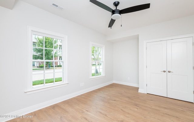 unfurnished bedroom featuring light wood-type flooring, ceiling fan, and a closet