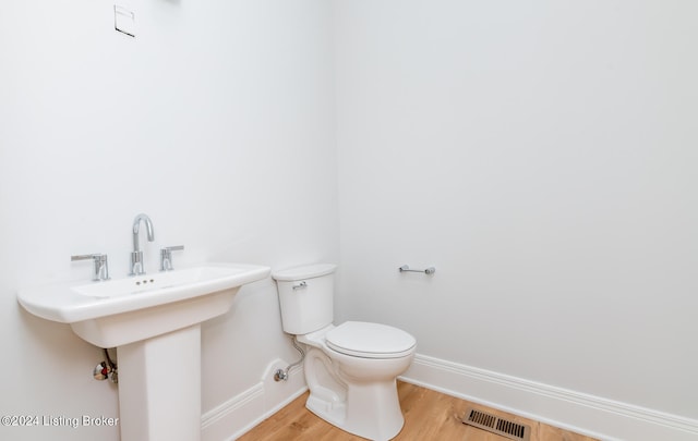 bathroom featuring hardwood / wood-style flooring and toilet