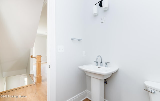 bathroom with hardwood / wood-style floors, toilet, and sink