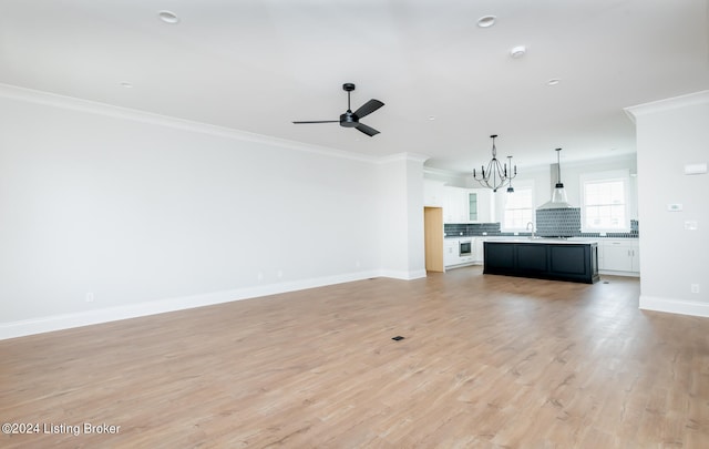 unfurnished living room featuring ceiling fan with notable chandelier, light hardwood / wood-style floors, crown molding, and sink