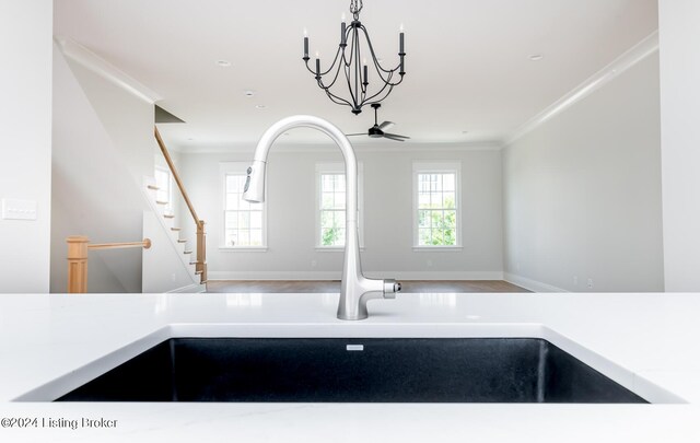 kitchen with wood-type flooring, a notable chandelier, hanging light fixtures, and ornamental molding