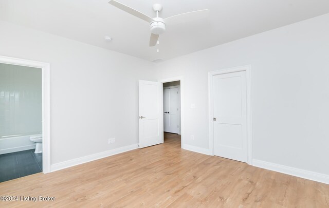 unfurnished bedroom with ensuite bathroom, ceiling fan, and light hardwood / wood-style flooring