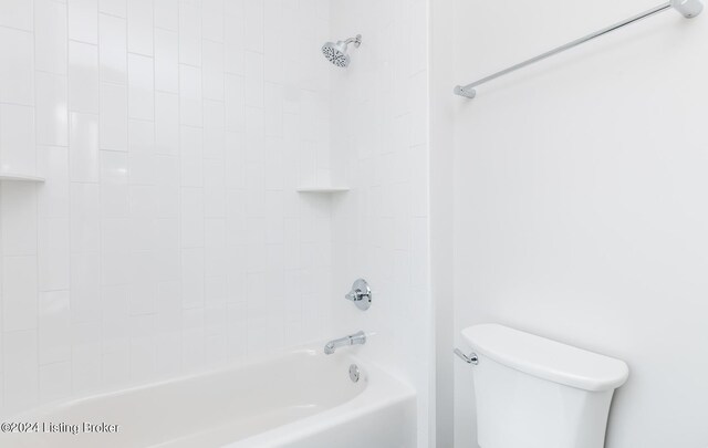 bathroom featuring tiled shower / bath combo and toilet