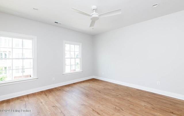 spare room with ceiling fan and light wood-type flooring