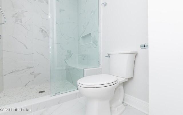 bathroom featuring toilet, tile patterned floors, and a shower with door