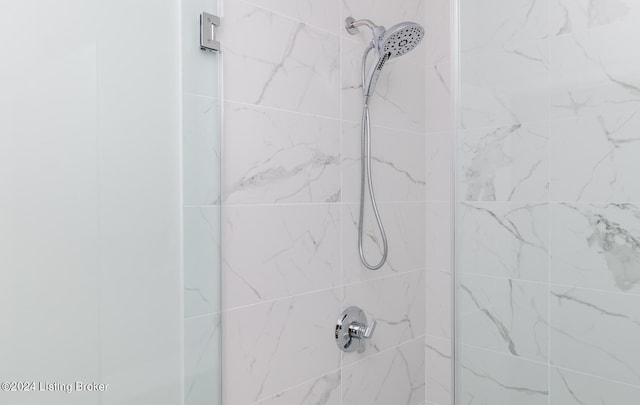 interior details featuring a tile shower