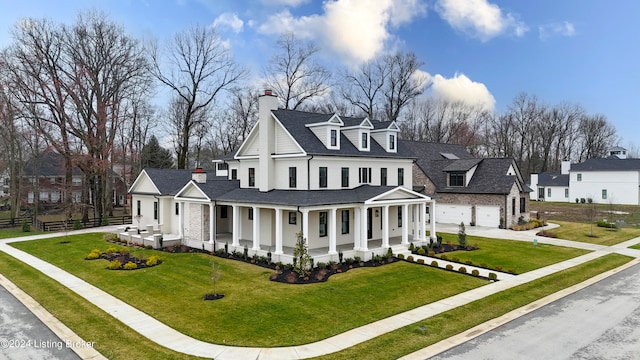 view of front of house with a front lawn, covered porch, and a garage