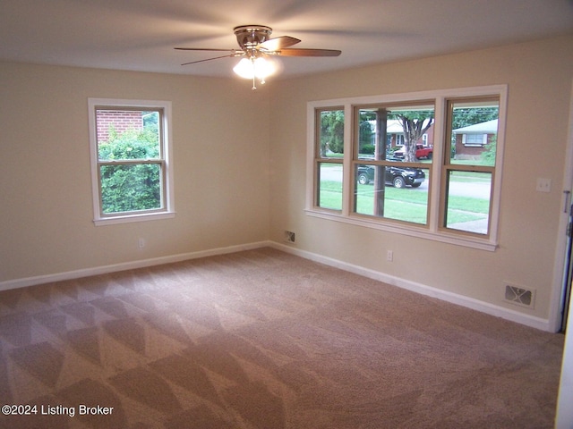 empty room featuring ceiling fan and carpet