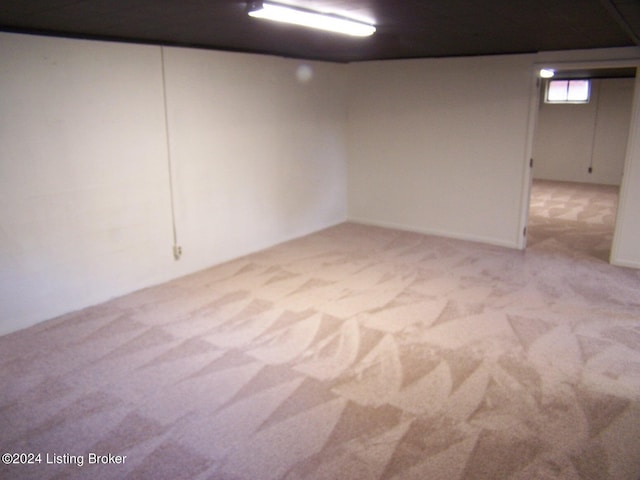 basement featuring light colored carpet