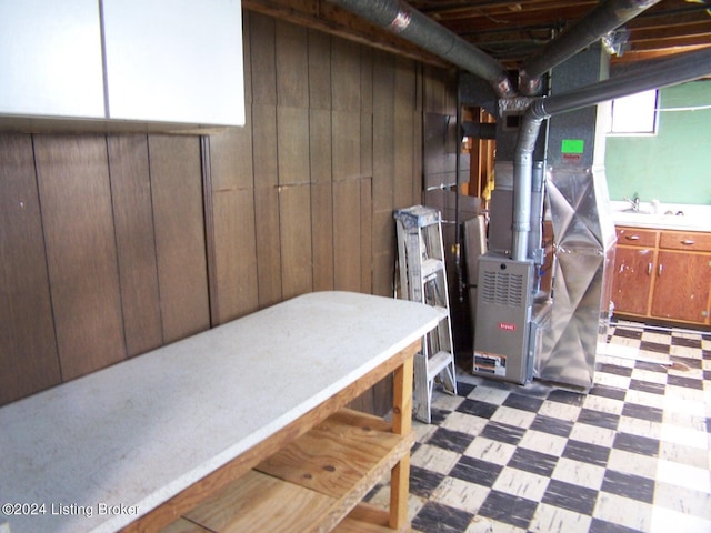 basement featuring wood walls and sink