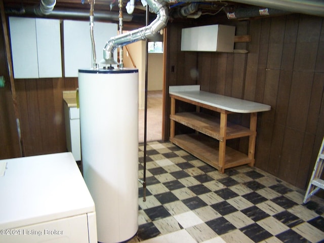 basement with washer / clothes dryer, water heater, and wooden walls