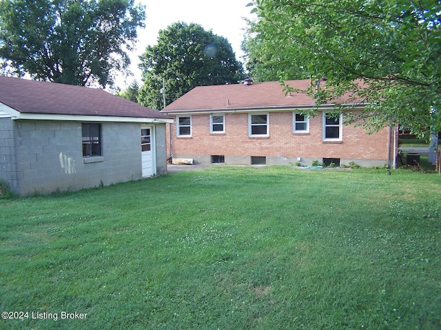 rear view of property with a lawn