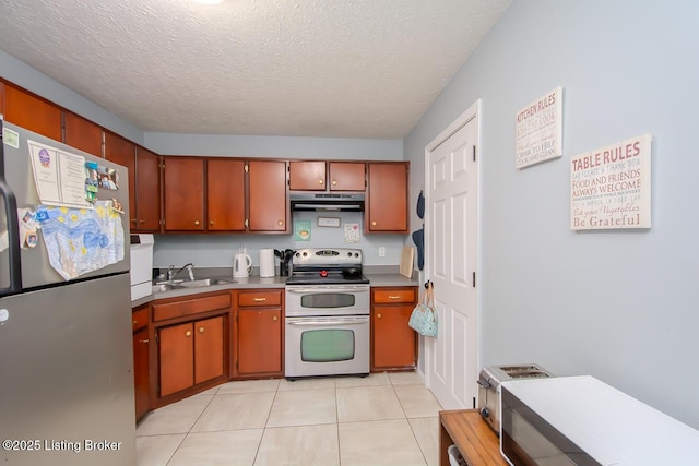 kitchen with light tile patterned floors, a textured ceiling, extractor fan, stainless steel appliances, and a sink