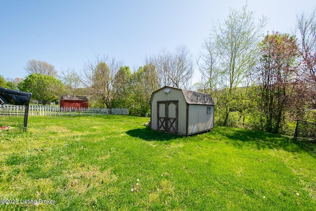 view of yard featuring a storage shed, fence, and an outdoor structure