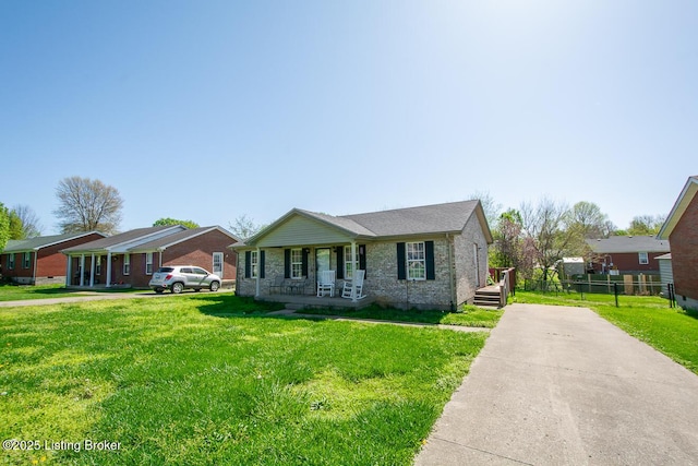 view of front facade with concrete driveway, covered porch, fence, and a front lawn