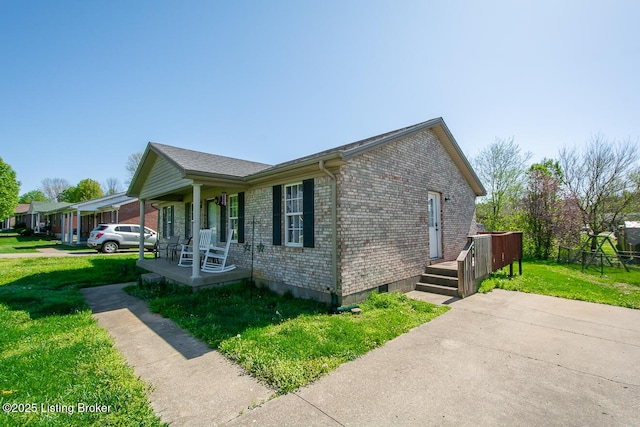 view of property exterior featuring a lawn, covered porch, and brick siding