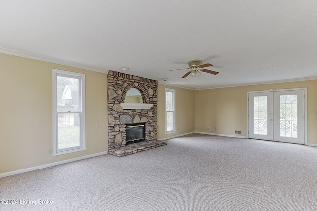 unfurnished living room with a fireplace, a wealth of natural light, light carpet, and ceiling fan