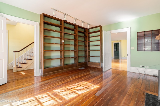 unfurnished room featuring rail lighting and hardwood / wood-style flooring