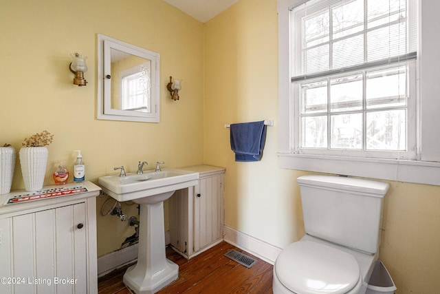 bathroom with toilet, plenty of natural light, and hardwood / wood-style flooring