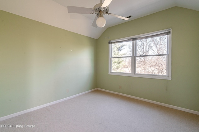 spare room with ceiling fan, light colored carpet, and vaulted ceiling