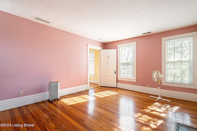 spare room with hardwood / wood-style floors and radiator